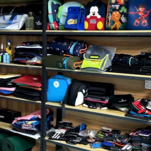 Various custom neoprene laptop bags, can coolers, and tote bags displayed on UooSport sample shelves