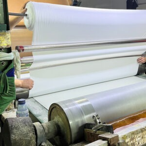 Automatic neoprene fabric lamination machine operating in UooSport factory production line processing raw materials